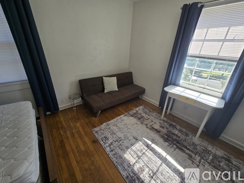 A living room with a brown sofa and a grey rug.