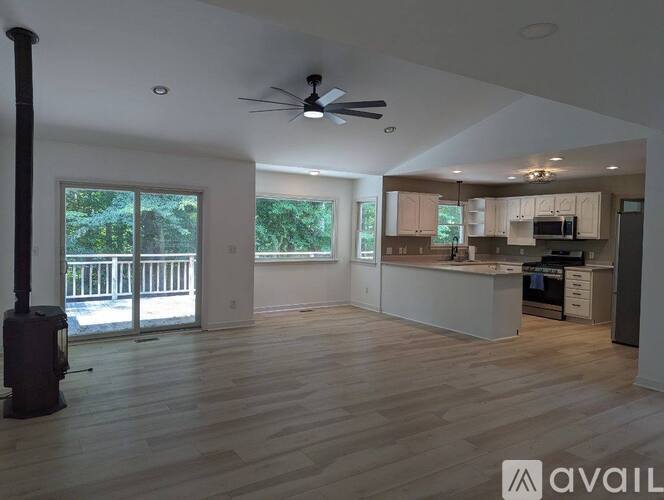 A spacious living room with a ceiling fan and a fireplace.