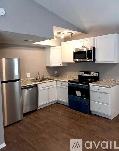 A kitchen with white cabinets and a stainless steel refrigerator.