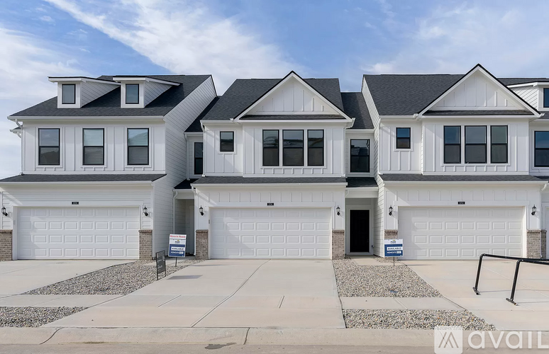 A large, modern house with a white exterior and multiple garages.