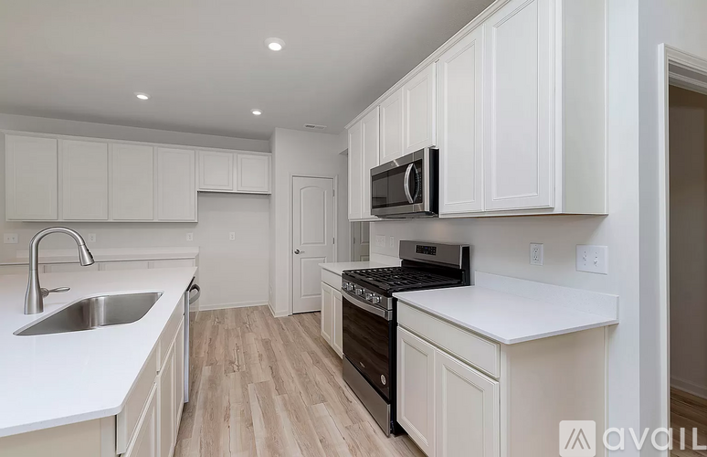 A kitchen with white cabinets and a black stove top oven.