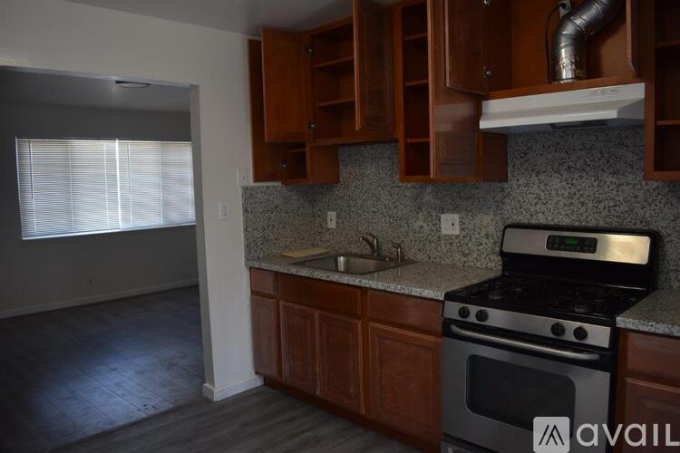 A kitchen with a stove and wooden cabinets.