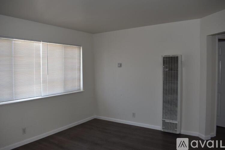 A room with a window and a wall-mounted air conditioning unit.