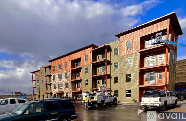 A large multi-story building with a parking lot in front.