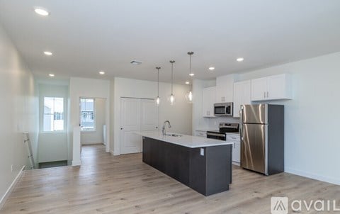 A kitchen with a black island and stainless steel appliances.