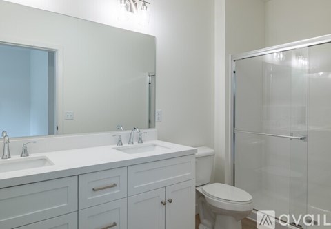 A white bathroom with a toilet, sink, and mirror.
