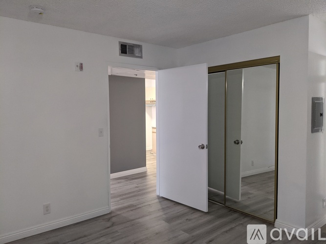 A room with a white door and a mirror on the wall.