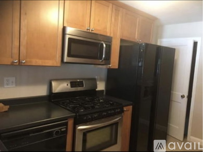 A kitchen with black appliances and wooden cabinets.