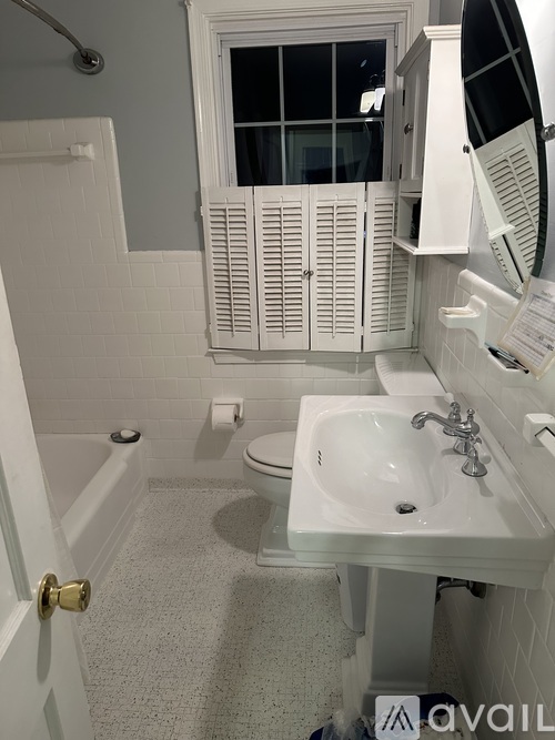 A bathroom with a toilet, sink, and window.