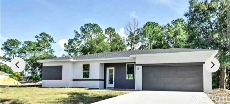A modern two-car garage with a white exterior and a black roof.