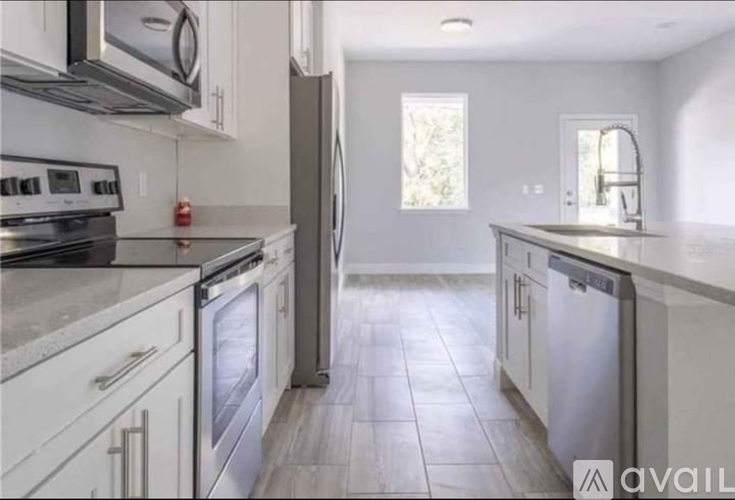 A kitchen with white cabinets and stainless steel appliances.
