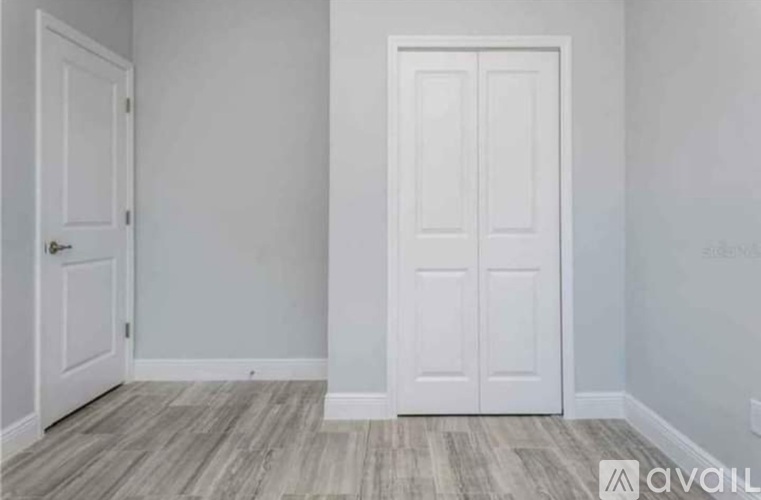 A room with a white door and a white wall.