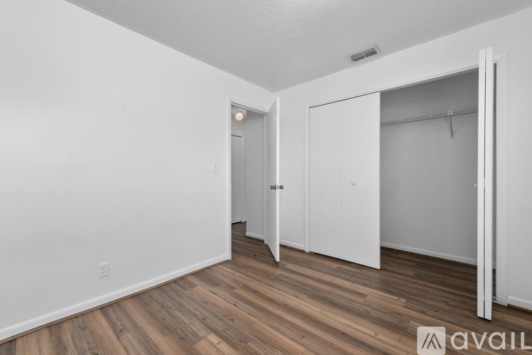 A room with a white door and a white closet with a hanger.