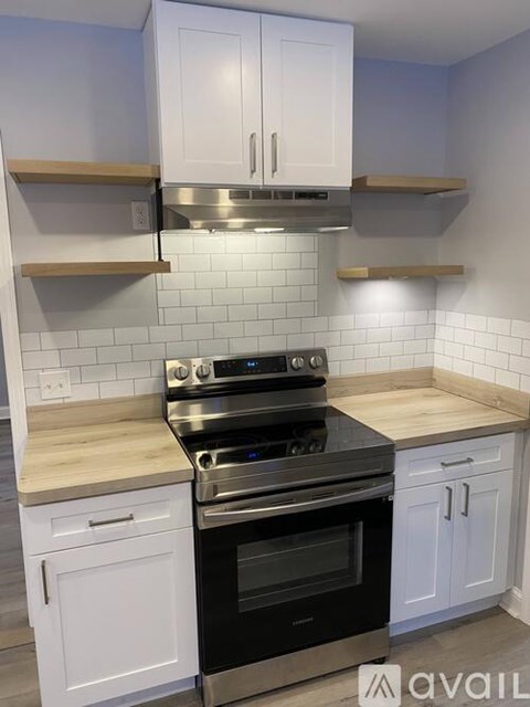 A kitchen with a black stove top oven and white cabinets.
