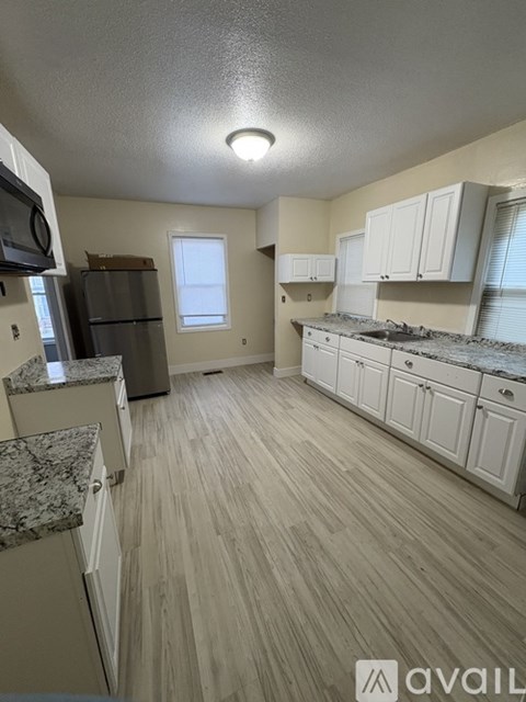 A kitchen with white cabinets and a granite countertop.