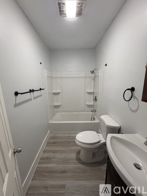 A bathroom with a toilet, sink, and bathtub.