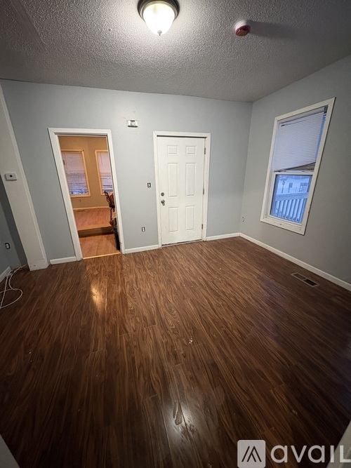 A room with wooden flooring and two white doors.