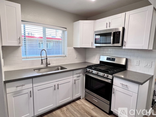A kitchen with white cabinets and a black stove top oven.