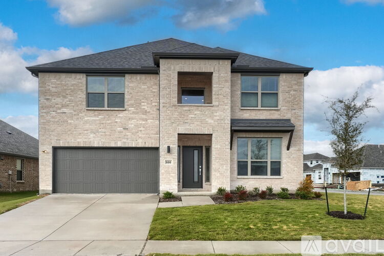 A modern house with a grey garage door and a black roof.