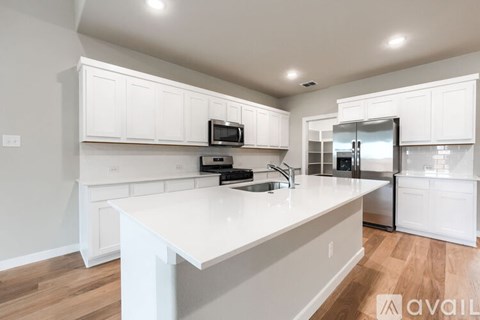 A kitchen with white cabinets and a white island.