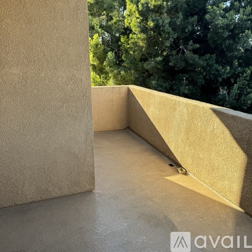 A balcony with a concrete floor and wall.