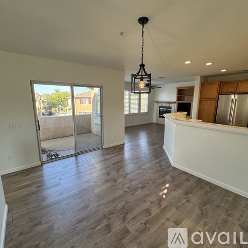 A spacious kitchen with a refrigerator, oven, and a dining table with chairs.