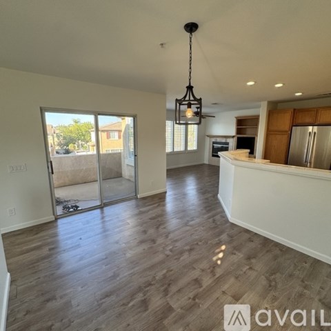A spacious kitchen with a refrigerator, oven, and a dining table with chairs.