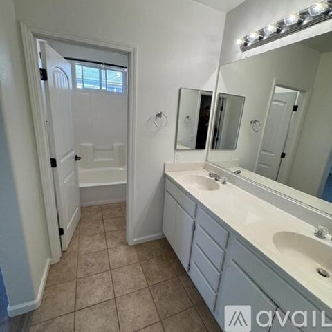 A spacious room with wooden flooring and a hanging light fixture.