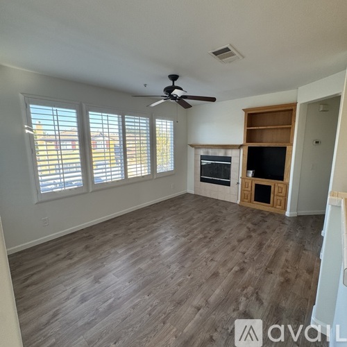 A living room with a ceiling fan and a television.