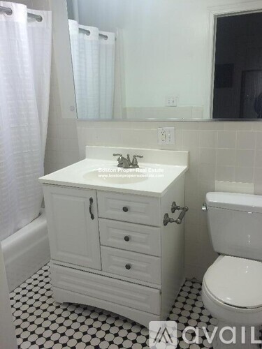A white bathroom with a sink, toilet and a mirror.