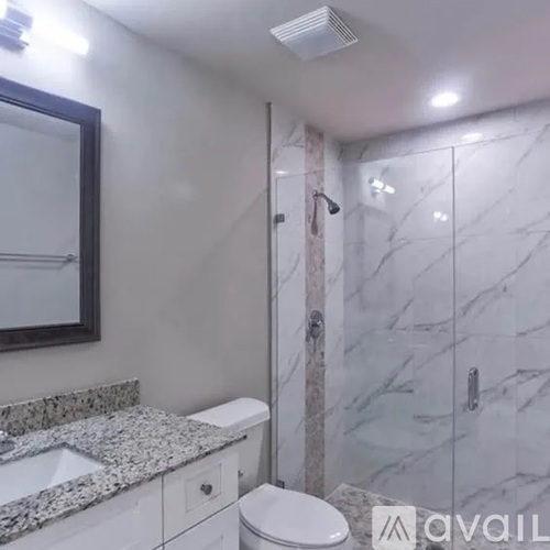 A bathroom with marble tiles and a white toilet.
