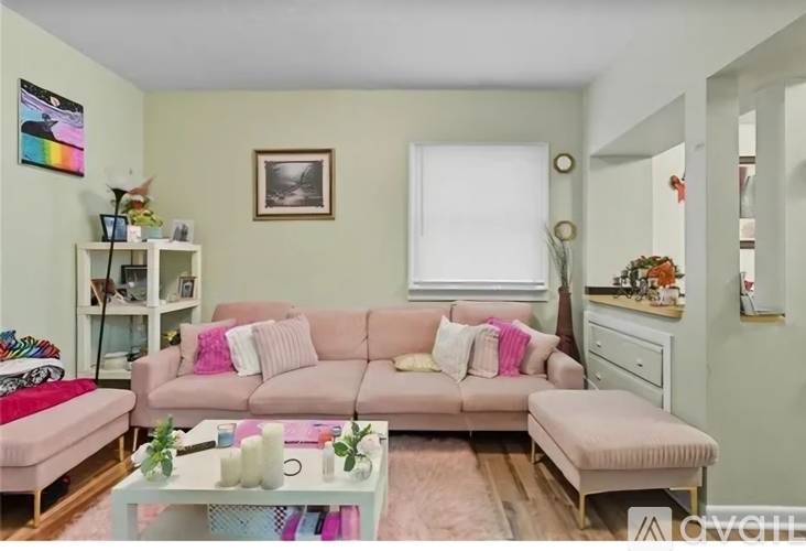 A living room with a pink couch and a white coffee table.
