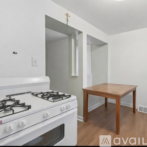 A kitchen with a white stove and white cabinets.