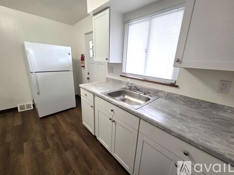 A kitchen with a white stove and white cabinets.