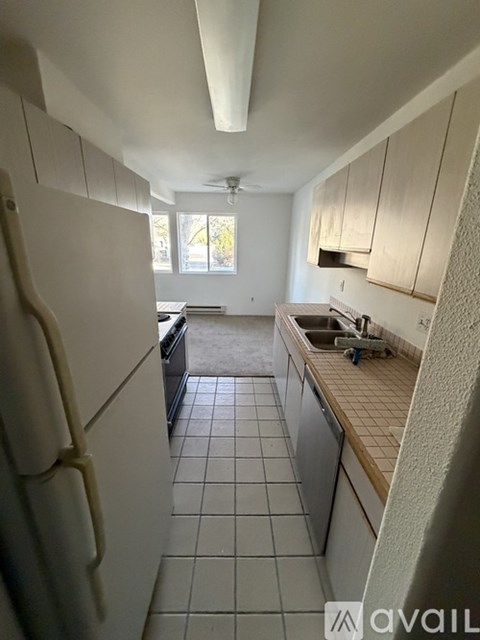 A kitchen with white cabinets and a tiled floor.