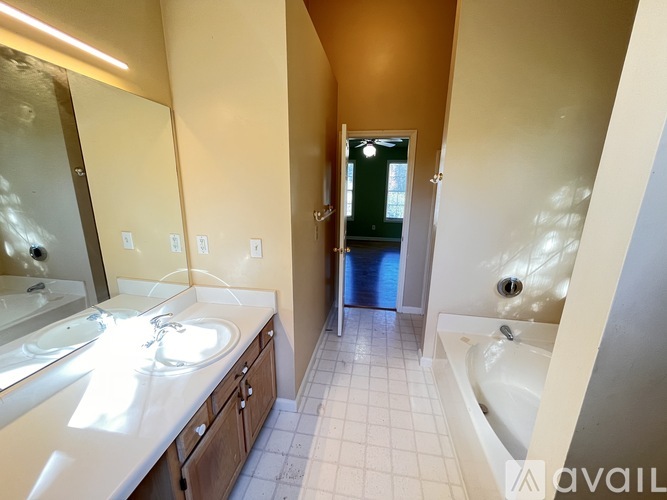 A bathroom with a sink, mirror, and bathtub.