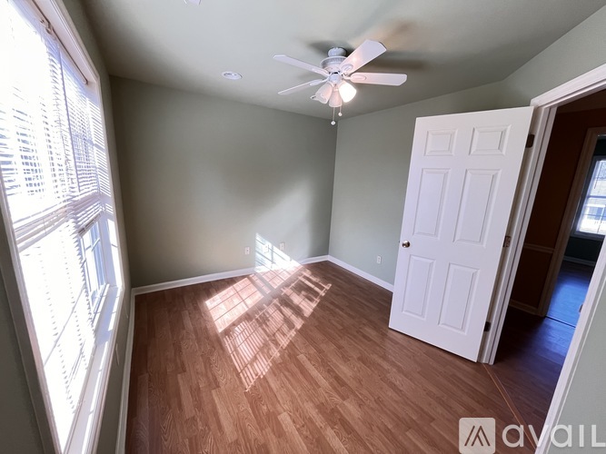 A room with a ceiling fan and wooden flooring.