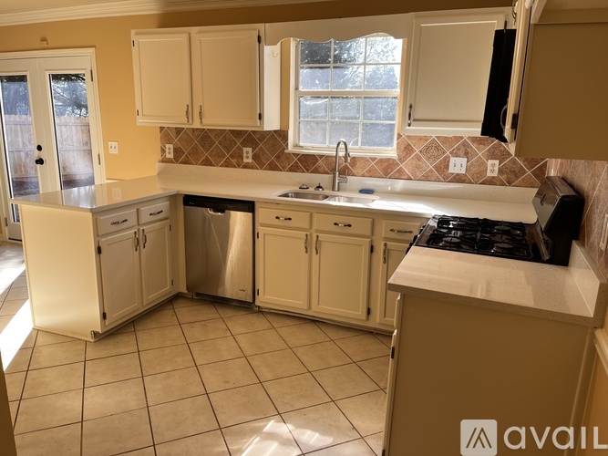 A kitchen with white cabinets and a brown counter.
