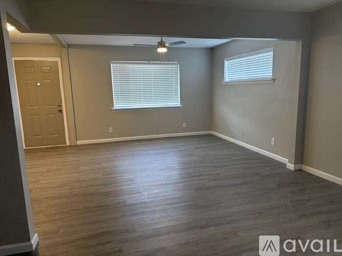 A room with wooden flooring and a ceiling fan.