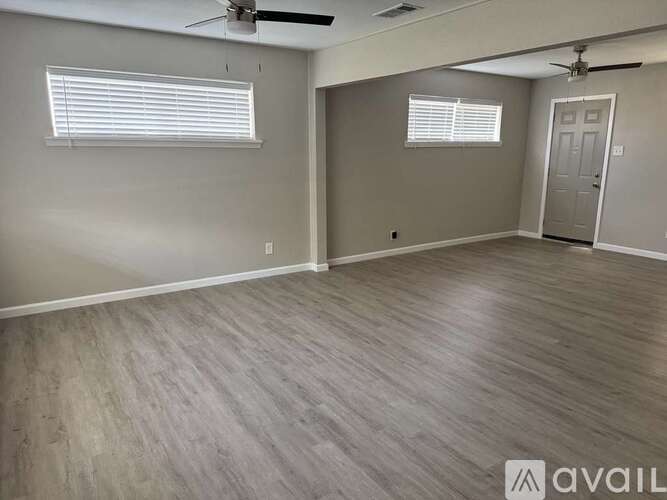 A room with a ceiling fan and a door.