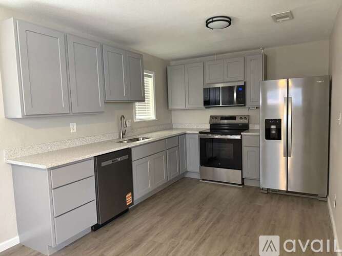 A kitchen with a refrigerator, oven, and microwave.