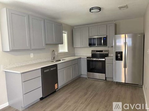 A kitchen with a refrigerator, oven, and microwave.