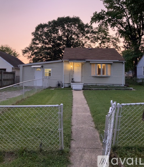 A small house with a fence in front of it.
