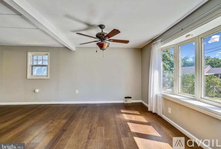 A room with a ceiling fan and a window.