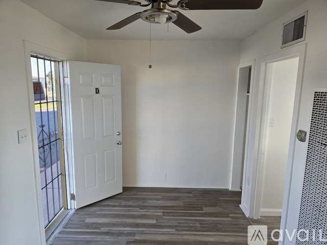 A room with a ceiling fan and a sliding glass door.