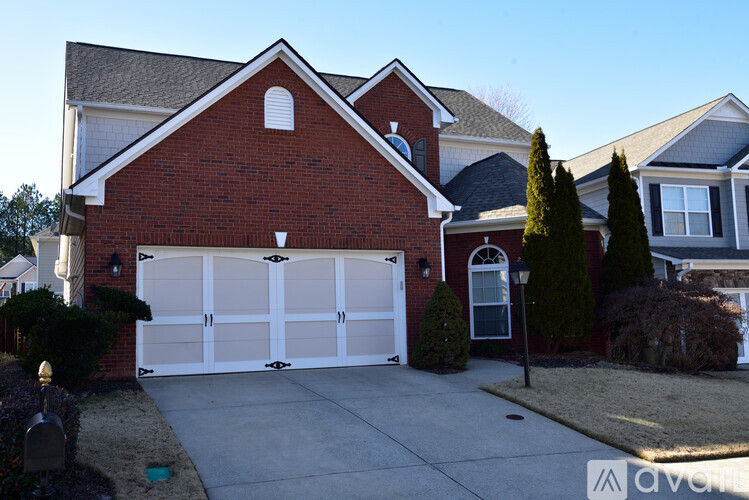 A red brick house with a white garage door.