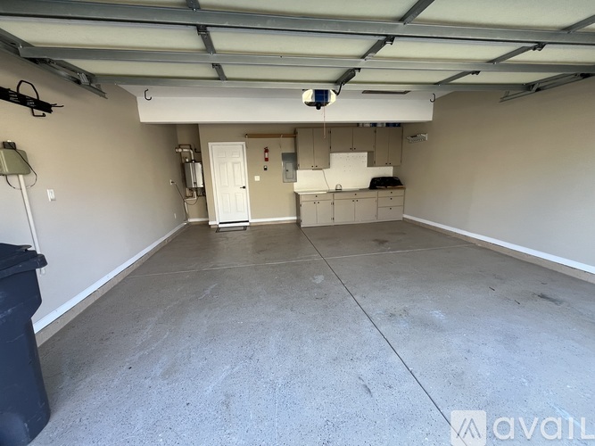 A spacious garage with a white door and a black bin.