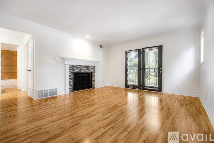 A spacious living room with wooden flooring and a fireplace.