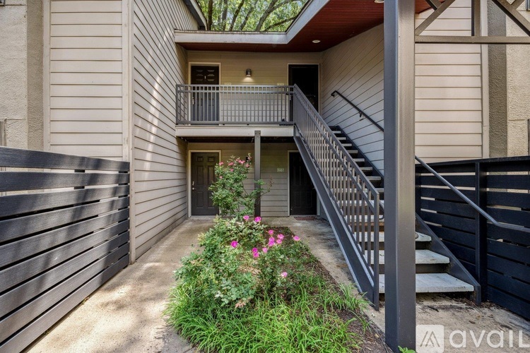 A house with a balcony and stairs leading to the entrance.