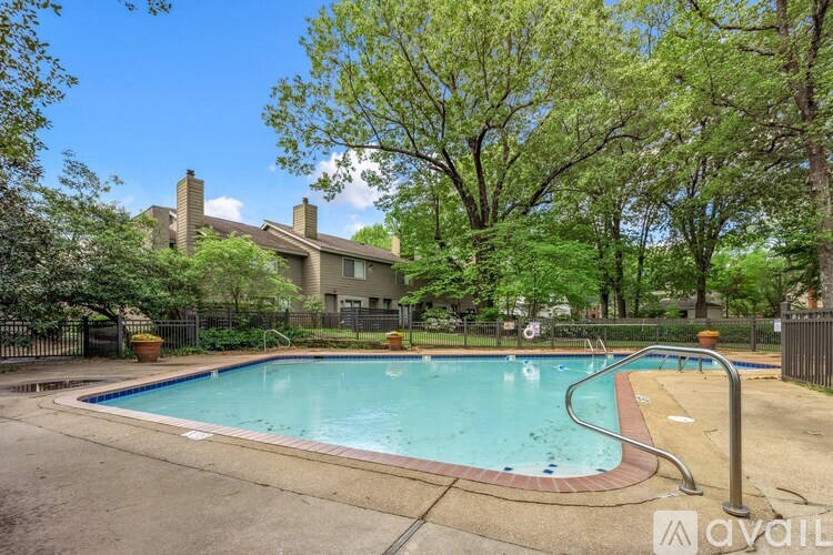 A swimming pool surrounded by a fence and trees.